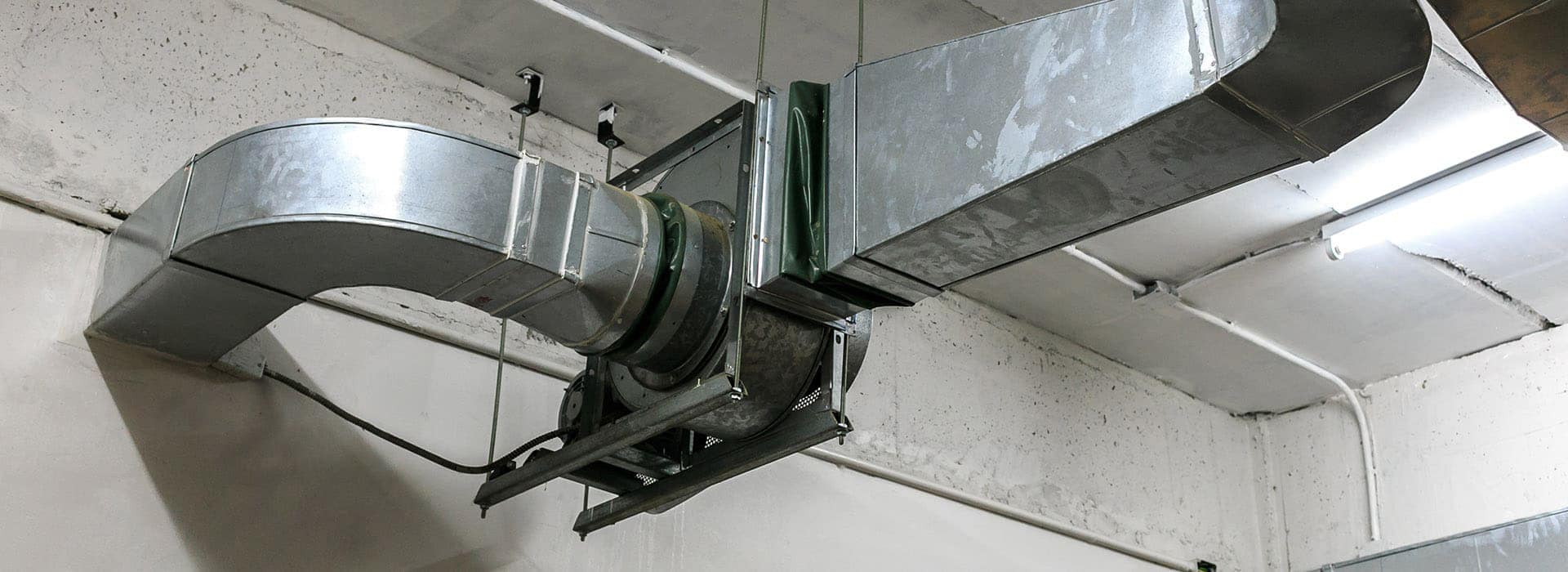 Sheet-metal ductwork running along a basement ceiling