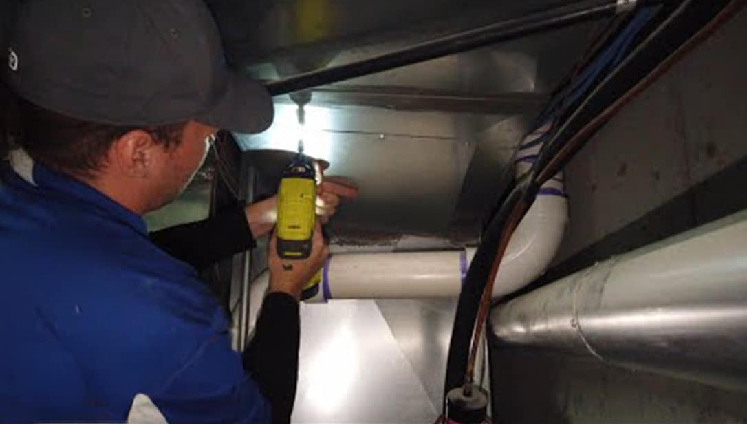 Technician inspecting the inside of a duct with a hand-held camera