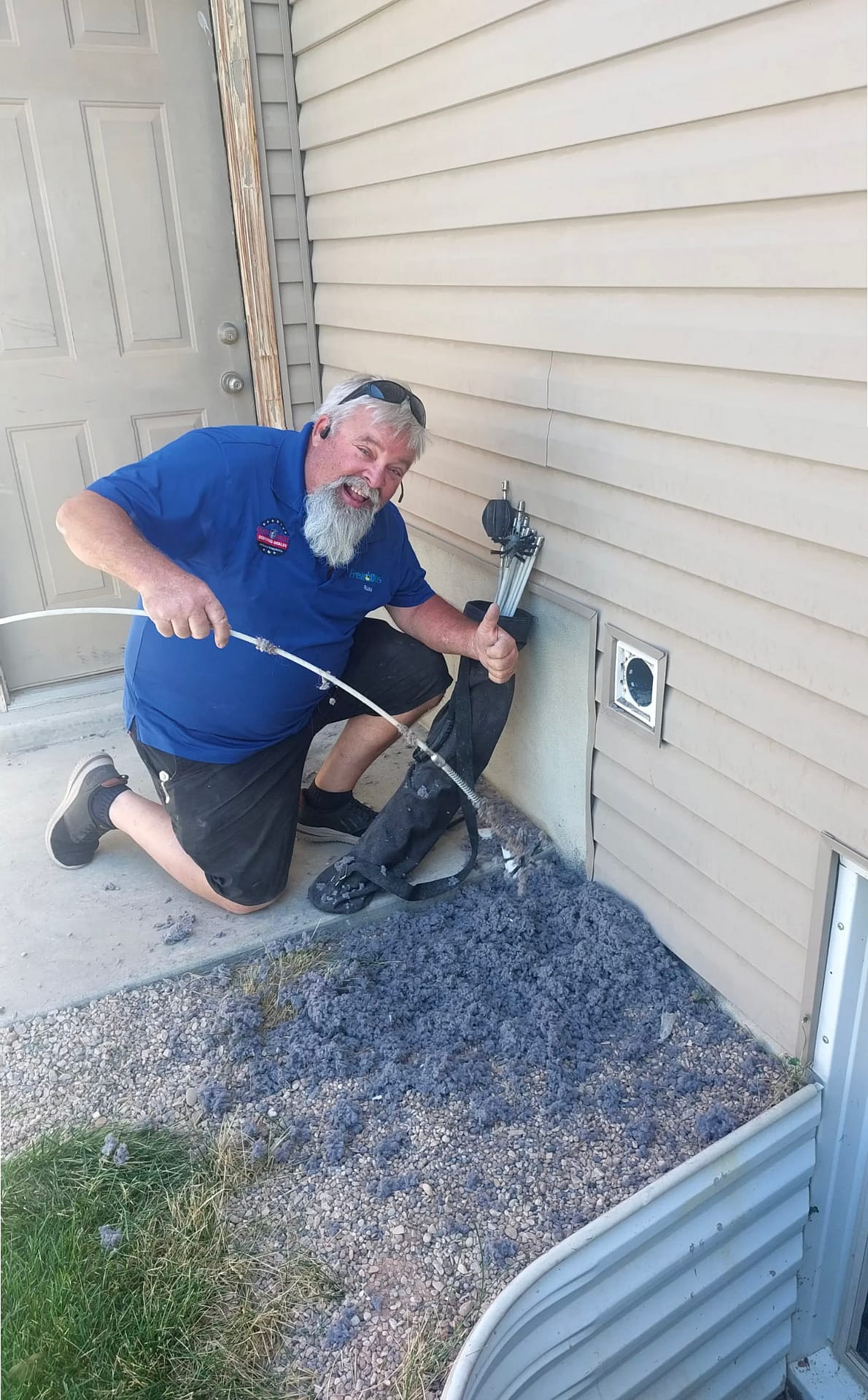 Exterior dryer vent being cleared, with a large pile of removed lint