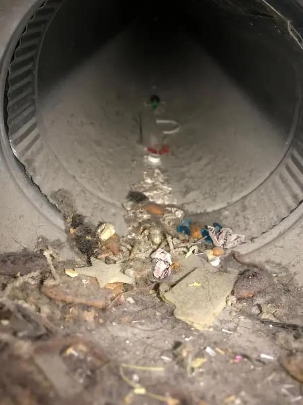 Inside of a round duct before cleaning, holding construction debris