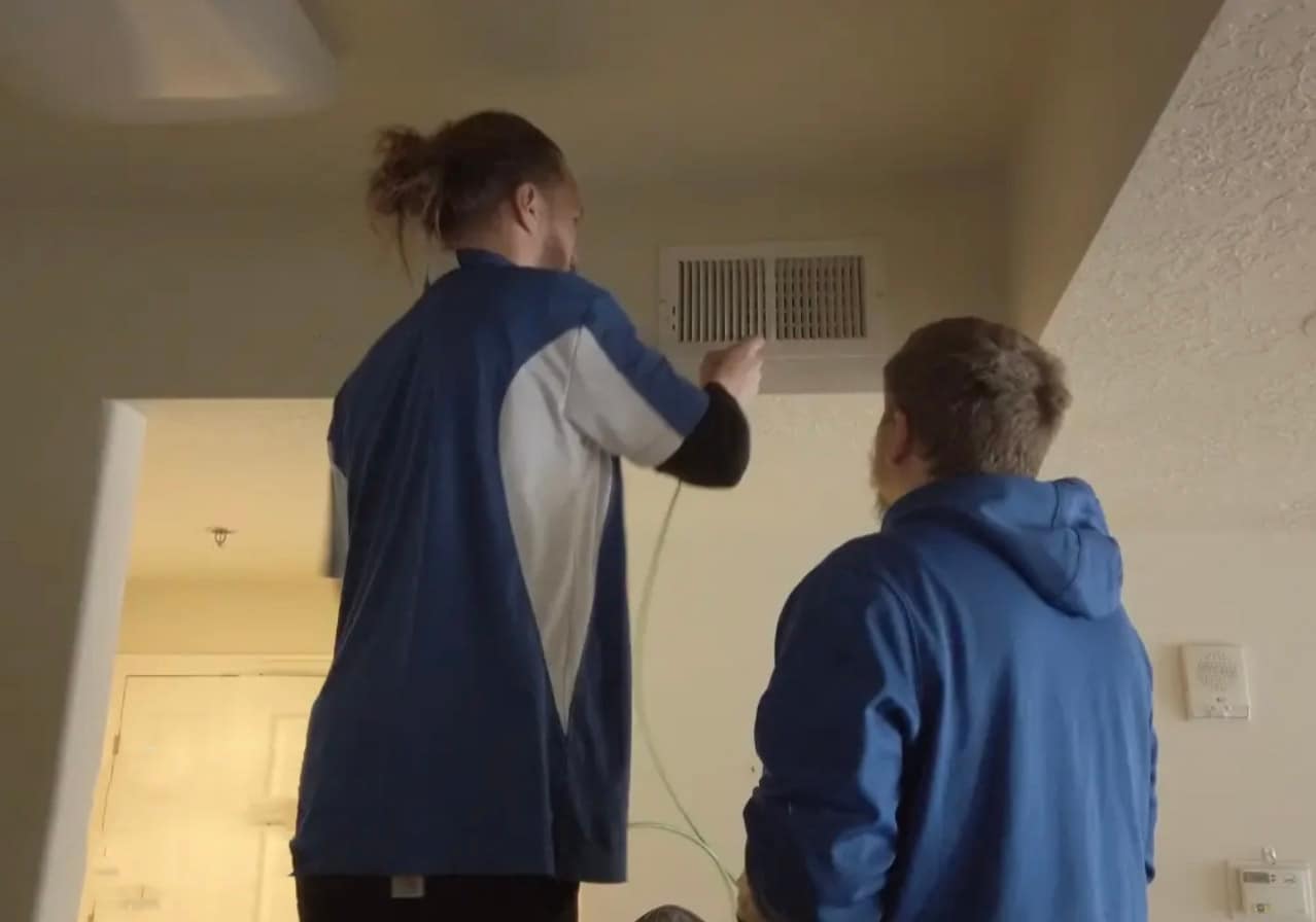 Fresh Ducts technicians cleaning a ceiling register inside a customer's home