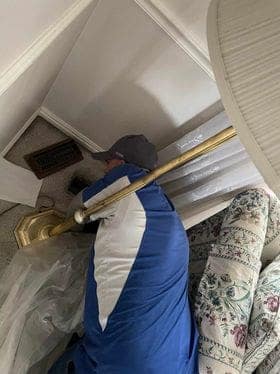Fresh Ducts technician agitating a residential air vent during cleaning